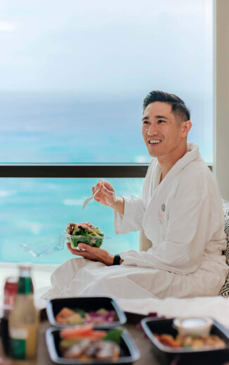 Man enjoying In-Room Dining from Halepuna Marketplace